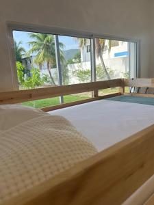 una cama en una habitación con una ventana grande en Front Beach Villa, Pool & Basket,  36 fotos más