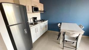 een kleine keuken met een koelkast en een tafel bij 06 Loft Espectacular - Aire Acondicionado, Consulado in Guadalajara