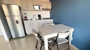 een keuken met een witte tafel en een koelkast bij 06 Loft Espectacular - Aire Acondicionado, Consulado in Guadalajara +2 foto's