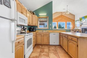 a kitchen with wooden cabinets and white appliances at 8194 - Southern Grace in Waves
