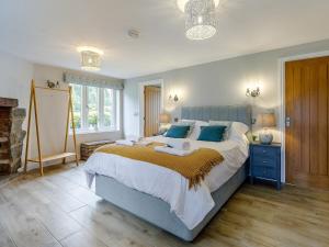 Kinshamにある1 Bed in Presteigne 78351の青い枕が付いた大きなベッドのある寝室