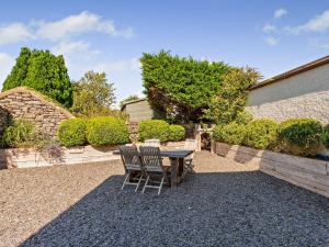 a patio with a table and chairs on gravel at 2 Bed in Cartmel LCC47 in Cartmel