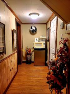 a hallway with a kitchen with a refrigerator and a microwave at Gîte du passant SADM, parc de la Gaspésie. in Sainte-Anne-des-Monts