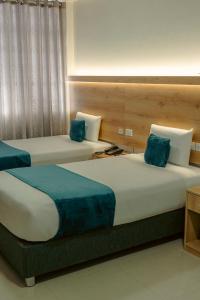 two beds with blue pillows in a hotel room at Antawa Hotel in Moquegua +28 photos