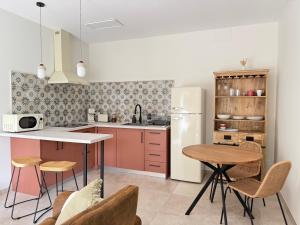 een keuken met een tafel, stoelen en een koelkast bij El Rincón de la Laguna in Ossa de Montiel
