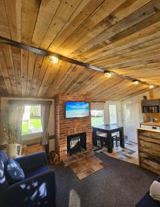 a living room with a fireplace and a flat screen tv at The Gull & Puffin Cresswell in Cresswell