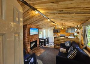 a living room with a couch and a fireplace at The Gull & Puffin Cresswell in Cresswell