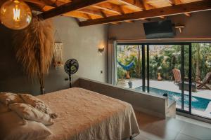 a bedroom with a bed and a view of a pool at Saccharum in Nocaima