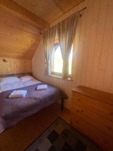 een slaapkamer met een bed en een raam in een hut bij Domki Florentyna Szklarska Poręba-Wojcieszyce in Wojcieszyce +64 foto's