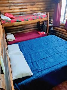 a bedroom with two bunk beds in a log cabin at casa quinta los teritos in Abasto
