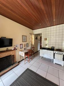 a large kitchen with a table and a kitchen with a stove at Chalé Verde Oliva in Camanducaia