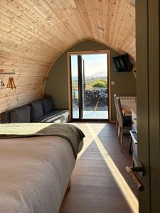 a bedroom with a bed and a desk and a couch at LUXURY POD - Hidden Hills Waterville Farm in Waterville