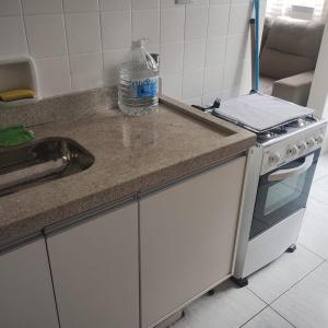 a kitchen counter with a sink and a stove at Apto a 100 mts da praia no Canto do forte com 1 vaga in Praia Grande +7 photos