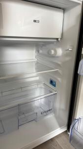 an empty refrigerator with its door open with a drawer at Paris Home in Bussy-Saint-Georges