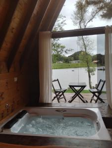 カンポ・アレグレにあるChalé do lagoの窓付きの客室で、ジャクジータブが備わります。 +2枚の写真