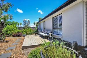 a garden with a bench and a house at 2 Settlement Court Bargara QLD 4670 in Windermere