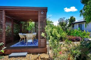 a small patio with a table in a garden at 2 Settlement Court Bargara QLD 4670 in Windermere +23 photos