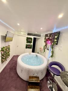 a large bathroom with a large soaking tub and a chair at Guest House Paradise Central in Maidstone