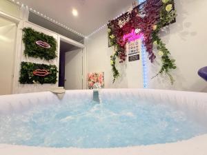 a hot tub in a room with plants on the wall at Guest House Paradise Central in Maidstone