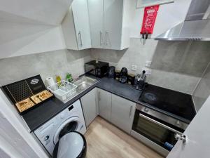 a small kitchen with a sink and a dishwasher at Guest House Paradise Central in Maidstone