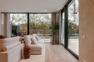 ein Wohnzimmer mit einem Sofa und großen Fenstern in der Unterkunft Warm family home by the sea - Villa La Madrague in Oostduinkerke-Bad + 46 Fotos