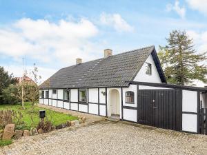 een wit en zwart huis met een garage bij 8 person holiday home in Sakskøbing-By Traum in Sakskøbing