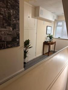 Un pasillo vacío con una mesa y una ventana. en The Nook, en Bedford