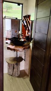 een badkamer met een wastafel op een houten tafel bij Chalé do lago in Campo Alegre +49 foto's