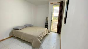 a bed in a white room with a window at Airport Residence - Vila Acácia I in Praia