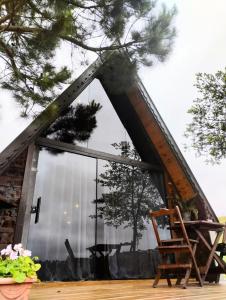 カンポ・アレグレにあるChalé do lagoの大きな窓と椅子が備わる客室です。