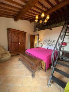 una camera da letto con un letto con copriletto rosa di Casa al Vento a Talla Altre 48 foto