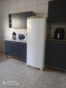 Cianorteにあるcasa para seu descansoの- 白い冷蔵庫付きのキッチン(青いキャビネット付)