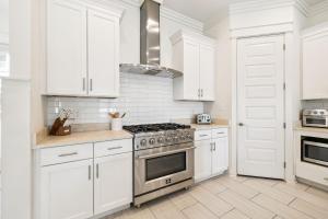 a white kitchen with a stove and white cabinets at Inlet Beach Reunion House by 30A Escapes in Inlet Beach