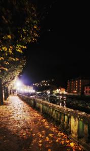 Una calle de la ciudad por la noche con hojas en la acera en Baciati dal Sole-Self check-in, en San Pellegrino Terme