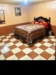 ein Schlafzimmer mit einem Bett und einem Schachbrettboden in der Unterkunft Hotel Venus in Las Victorias