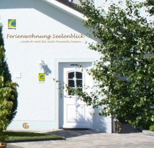 ein weißes Gebäude mit einer Tür und einem Baum in der Unterkunft Gemütliche Maisonette-Wohnung mit Fußbodenheizung in Berndorf