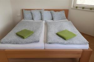a bed with two green pillows on it at Villa Slupečná in Lipno nad Vltavou