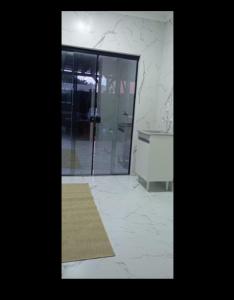 ein Badezimmer mit einer Glastür und einem Teppich in der Unterkunft Apartamento Praia do Sonho - Seu Refúgio Perfeito! in Palhoça