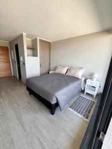 a bedroom with a bed and a side table at Refugio Valdiviano - Tu descanso junto al rio in El Cerrillo +15 photos