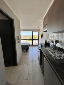 a kitchen with a view of a living room at Refugio Valdiviano - Tu descanso junto al rio in El Cerrillo