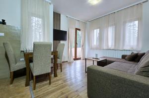 a living room with a couch and a dining room table at Apartmani Bijelic in Žabljak