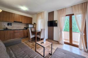 a living room with a couch and a table and a kitchen at Apartmani Bijelic in Žabljak +73 photos