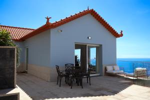 a patio with a table and chairs and the ocean at FLH Funchal Bay View Escape with Pool in São Gonçalo