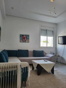 een woonkamer met een bank en een tafel bij Dorra house in La Marsa