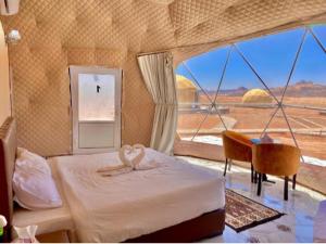 a bedroom with two white swans on a bed at Rum Aranda camp &Bubbles Hotel in Wadi Rum