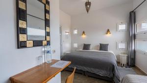 een kleine slaapkamer met een bed en een bureau bij Auberge Azul Ifni in Sidi Ifni