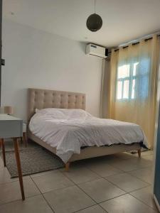 een bed in een slaapkamer met een raam en een tafel bij Dorra house in La Marsa +8 foto's