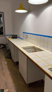 - une cuisine avec un long comptoir dans une pièce dans l'établissement Nouveau - Élégants appartements rénovés en centre-ville, à Aubenas