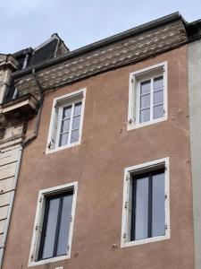 un bâtiment en briques brunes avec des fenêtres blanches dans l'établissement Nouveau - Élégants appartements rénovés en centre-ville, à Aubenas