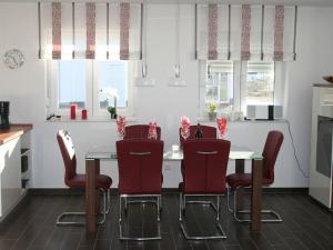 a kitchen with a table with red chairs and windows at Villa Kiek Ut in Trent +22 photos